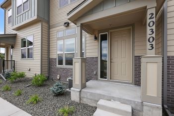 A modern house with a beige front door and a number 20303 on the wall.